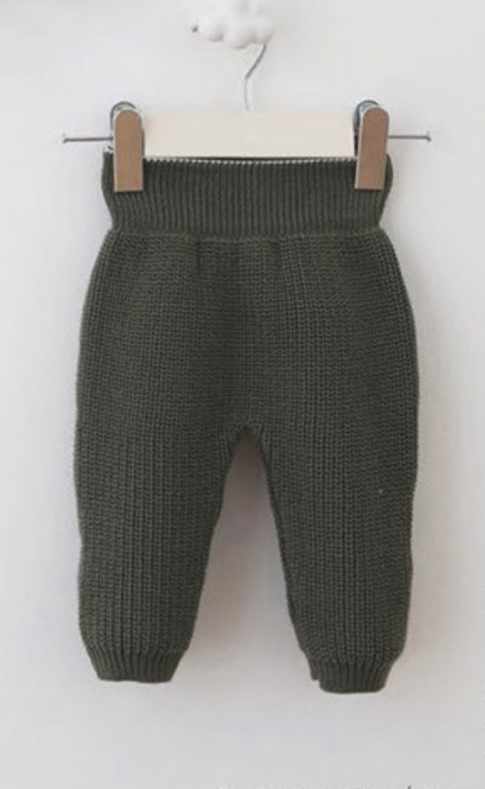 Dark green knitted baby pants on a white background