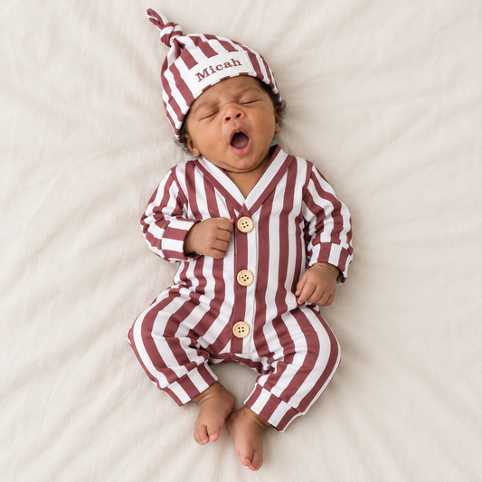 Illustrative lifestyle image of a newborn wearing the burgundy striped romper and personalized hat